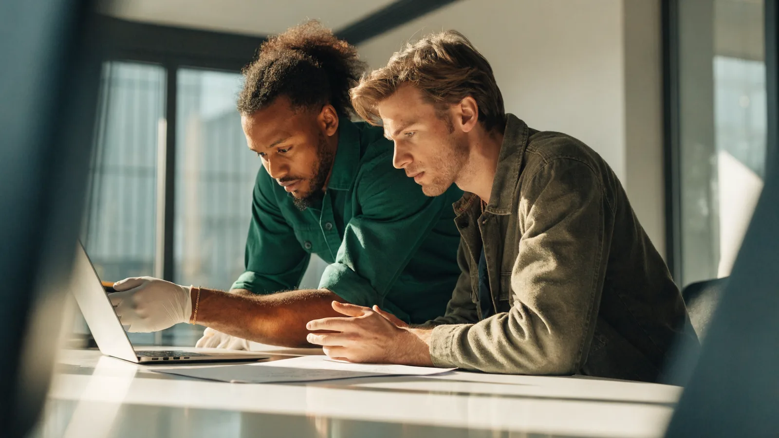 Photo of two pest-control business owners reviewing and signing a document as they choose pest control software at an office desk