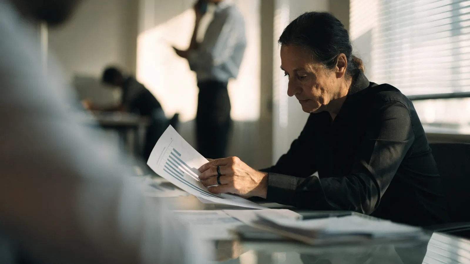 Photo of a pest control operator studying a printed bar-chart report to calculate pest control software and AI ROI at a desk.
