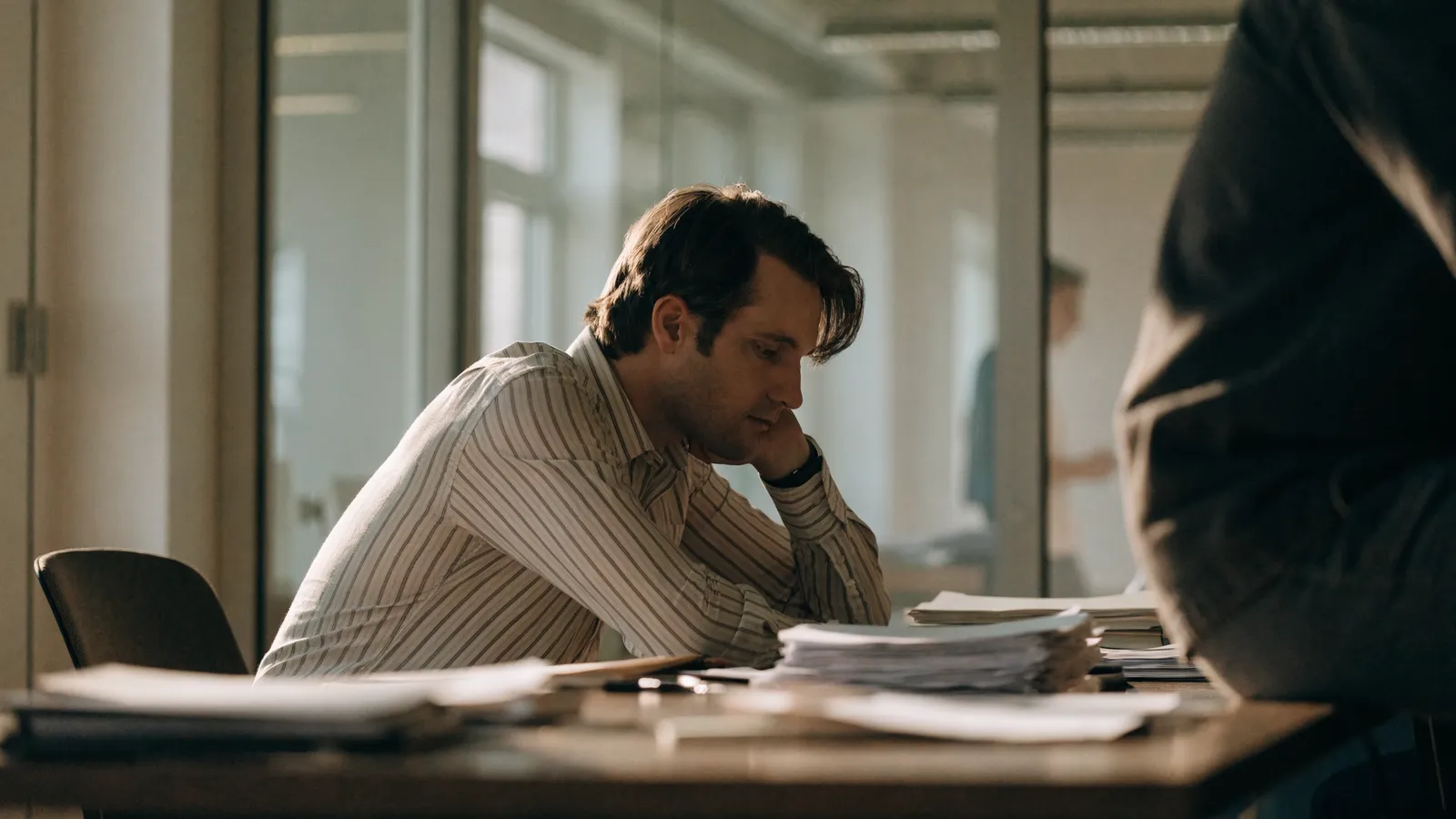 Photo of a pest control business owner studying a stack of vendor reports at his desk, comparing Solea AI alternatives.